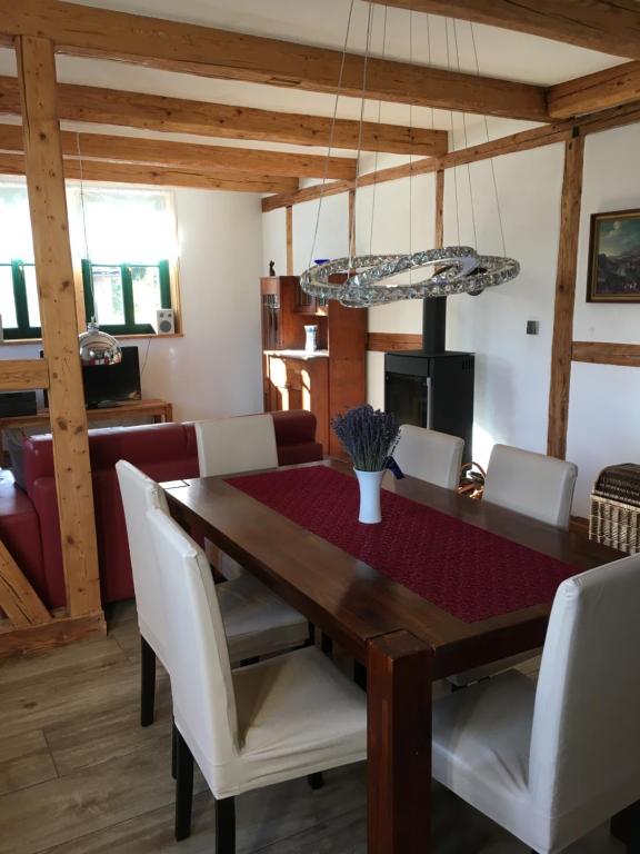 a dining room with a wooden table and white chairs at Schöne gemütliche Ferienwohnung mit Kamin I im Harz in Darlingerode