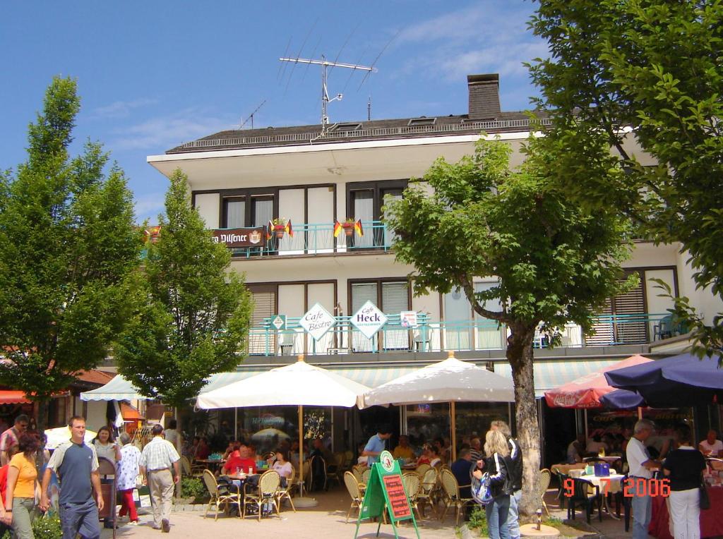 a group of people walking around a market in front of a building at Gästehaus Café Heck Titisee in Titisee-Neustadt