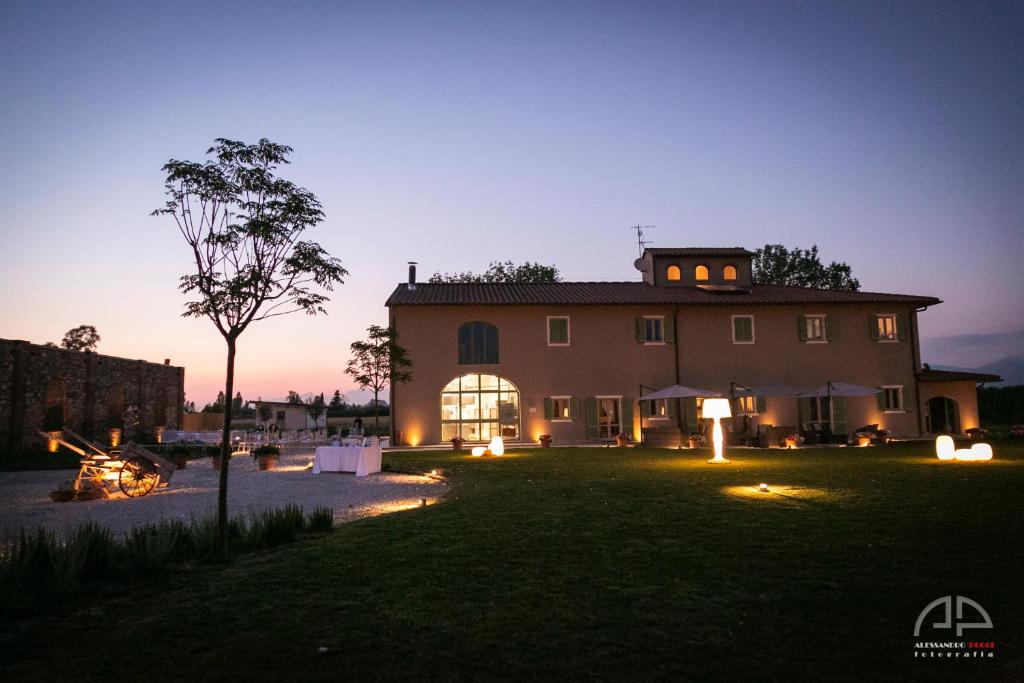 uma casa grande à noite com as luzes acesas em Fattoria L'Olmetto em Pisa