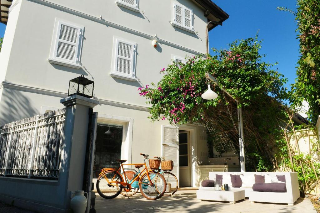 rower zaparkowany przed białym domem w obiekcie Olive Beach Forte dei Marmi w mieście Forte dei Marmi