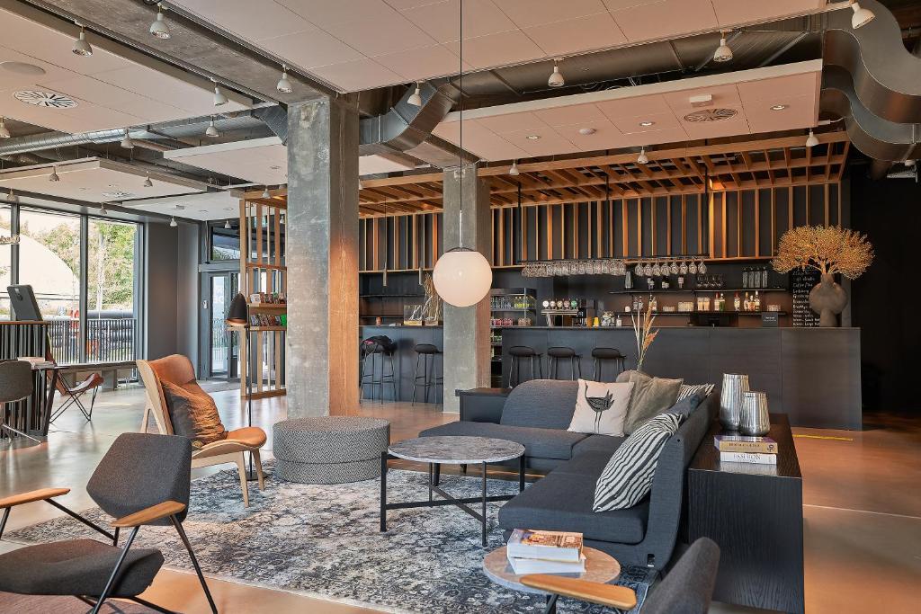 a lobby with a couch and chairs and a bar at Zleep Hotel Lyngby in Kongens Lyngby
