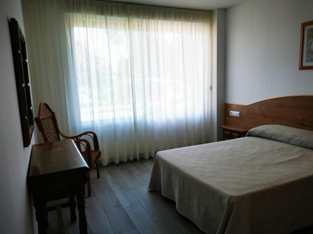 sypialnia z łóżkiem i dużym oknem w obiekcie Loft Pedras Negras w mieście San Vicente do Mar