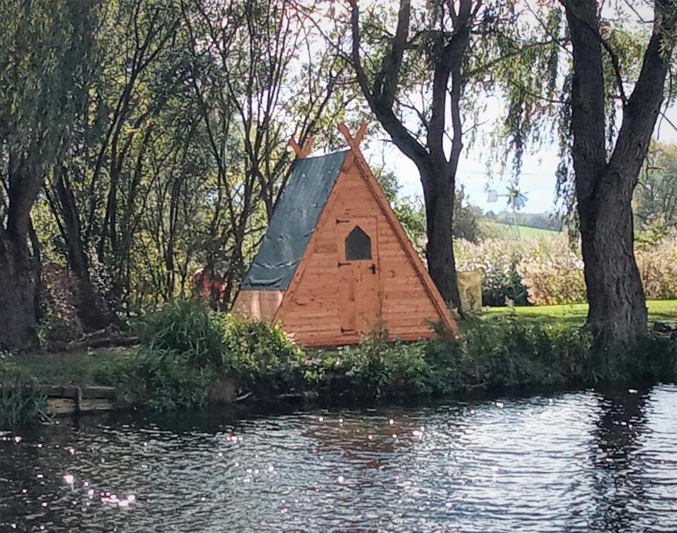 a small house in the middle of a pond at "George's" lakeside wooden tipi in Sudbury