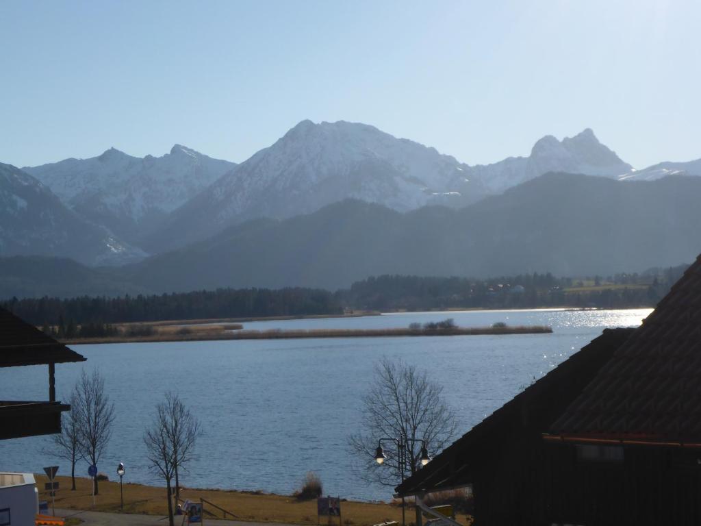 vista su un lago con montagne sullo sfondo di Gästehaus Guggomos "Das Allgäustyle" a Füssen