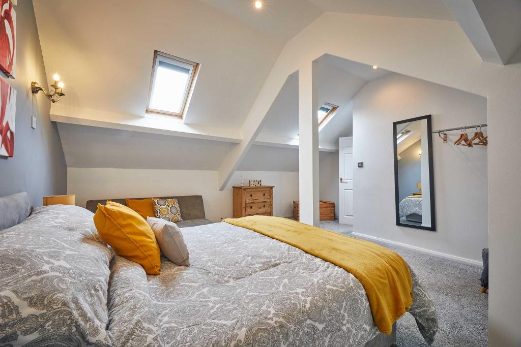 Host & Stay - Skyview في Seaton Delaval: غرفة نوم بسرير كبير مع مخدات صفراء
