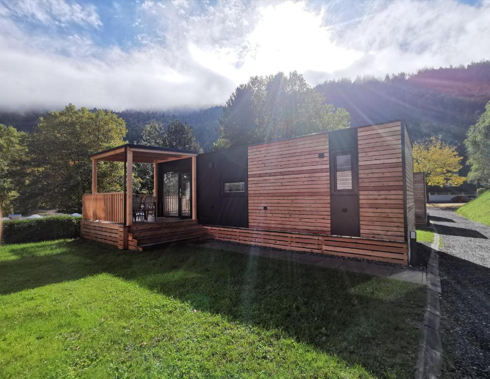 a small house in the middle of a yard at Seecamping Berghof - Mobilheime in Landskron