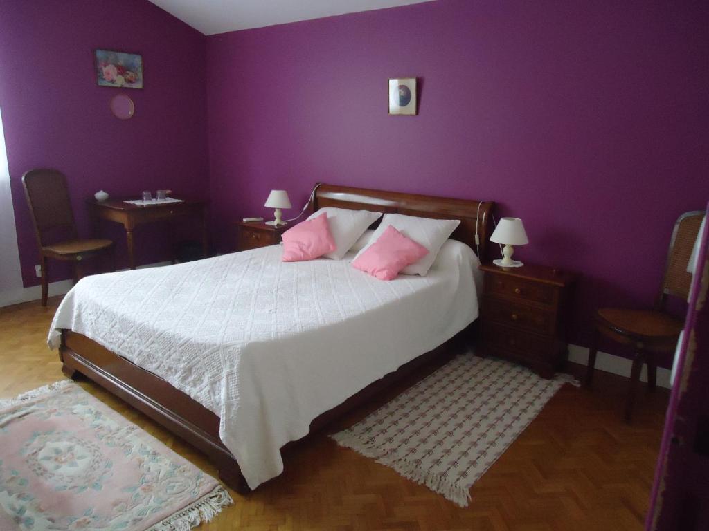 CarignanにあるA la Cerisaieの紫の壁のベッドルーム1室、ピンクの枕付きのベッド1台が備わります。