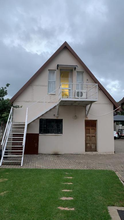 a white house with a staircase on the side of it at Hi Loft Living in Newcastle