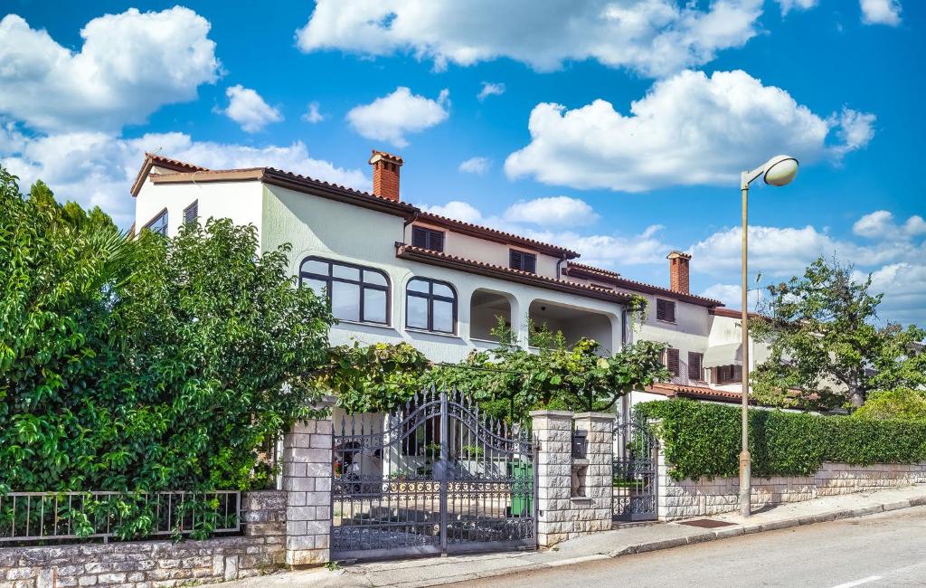 ein weißes Haus mit einem Zaun in der Unterkunft Marija in Poreč
