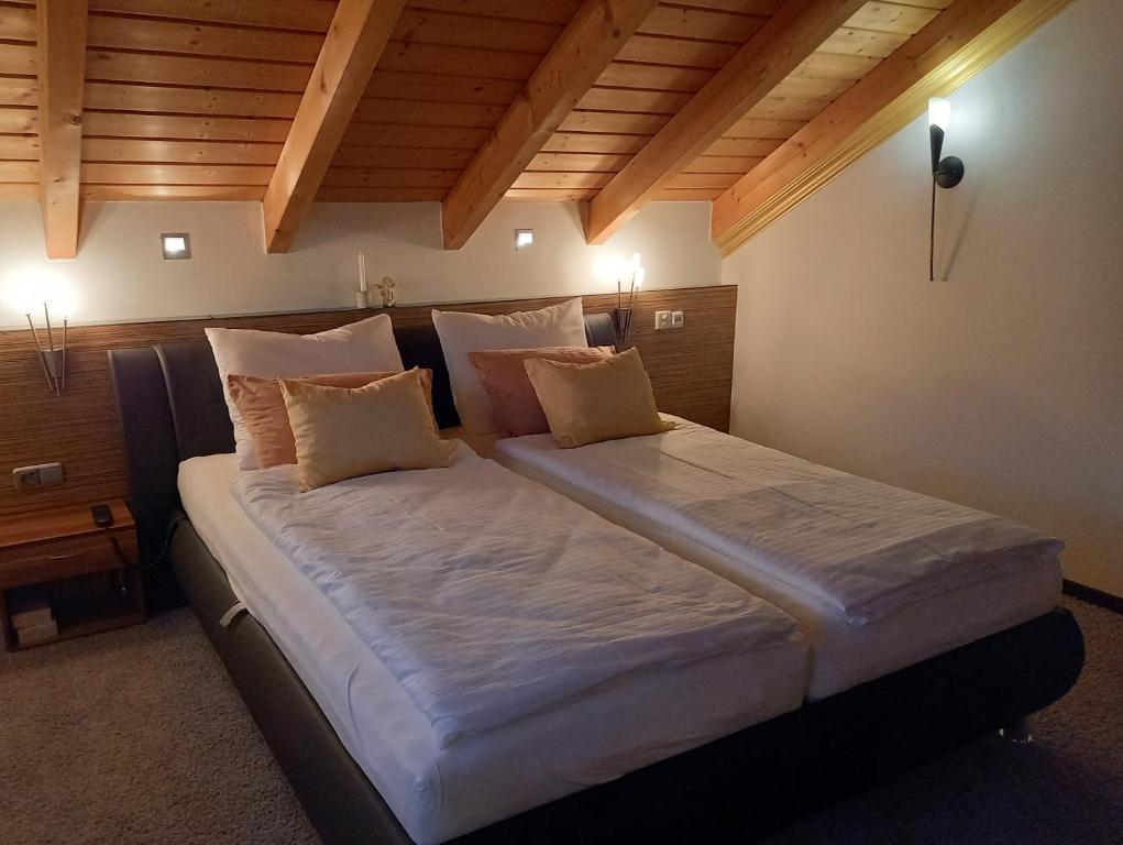Cama grande en habitación con techo de madera en Maisonette Deluxe by fewo-amperland, en Olching