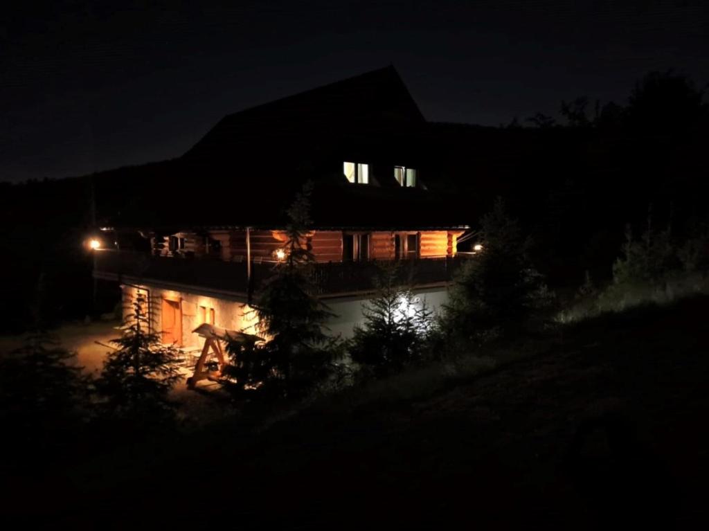 a house at night with a person on a bike at Górska Hacjenda in Brenna