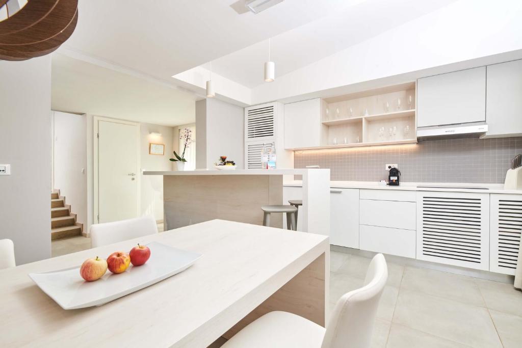 eine Küche mit einem weißen Tisch mit Äpfeln darauf in der Unterkunft Villas Bellevue Plava Laguna in Poreč