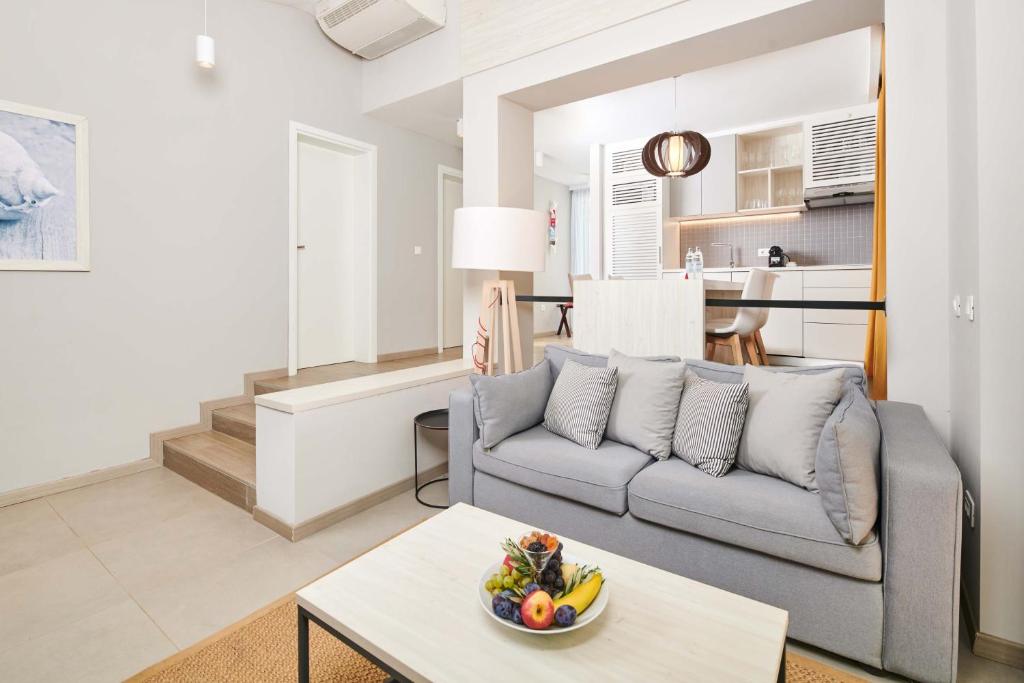 ein Wohnzimmer mit einem Sofa und einer Obstschale auf einem Tisch in der Unterkunft Villas Bellevue Plava Laguna in Poreč