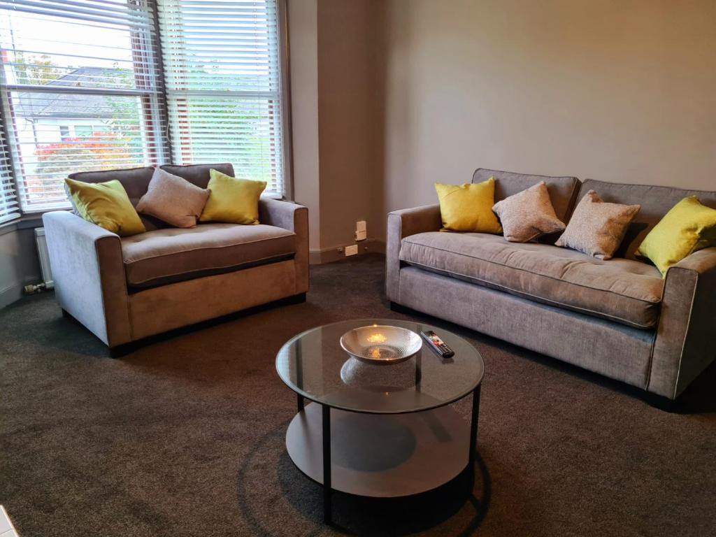 a living room with two couches and a coffee table at Royal Victoria House in Dundee