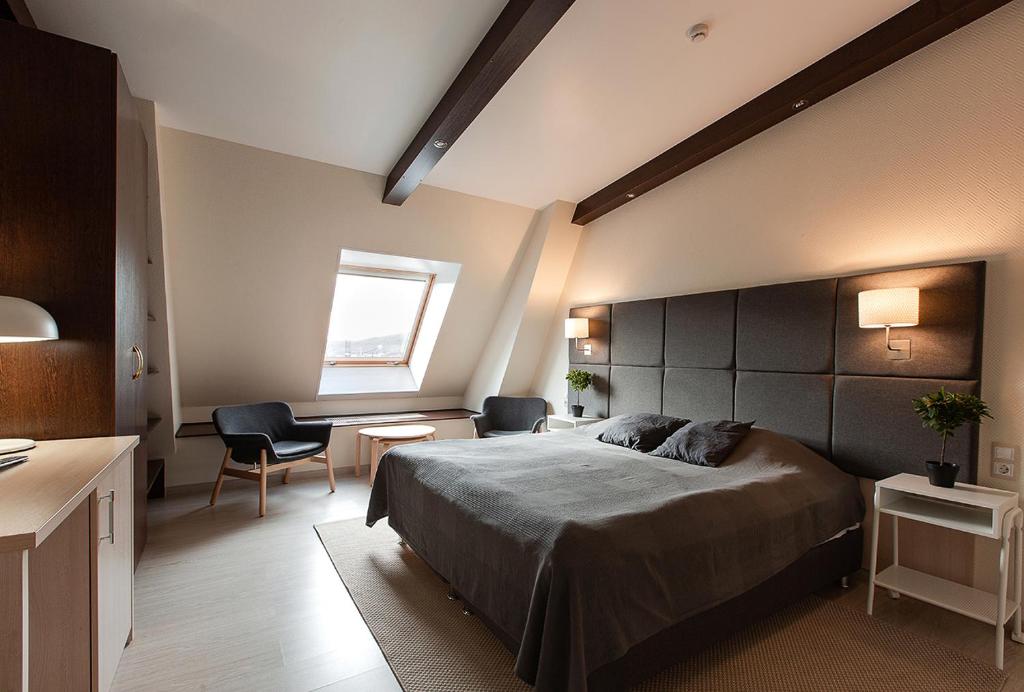 1 dormitorio con cama, escritorio y ventana en Glarus Hotel, en Murmansk