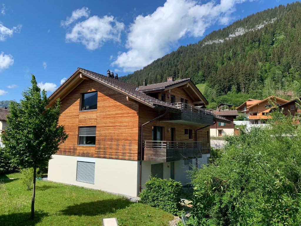 a house with a mountain in the background at Apartment Kohlmeise in Zweisimmen