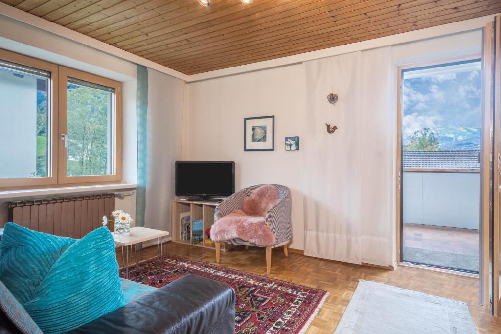 a living room with a chair and a television at Försterhaus Wohnung Obergeschoss in Egg