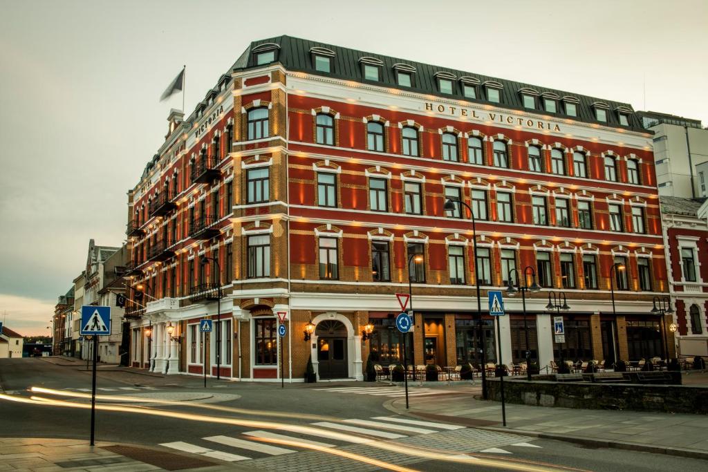 ein großes rotes Gebäude an der Ecke einer Straße in der Unterkunft Hotel Victoria in Stavanger