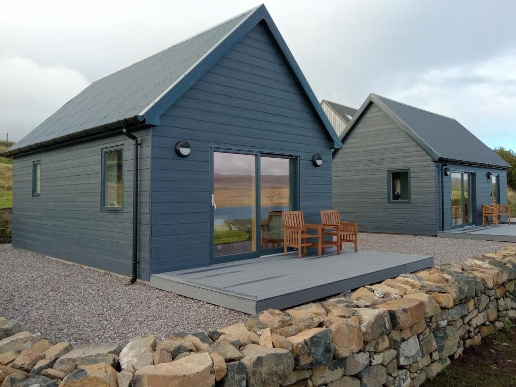 a blue house with a table and chairs in front of it at Treaslane Stable Rooms in Skeabost