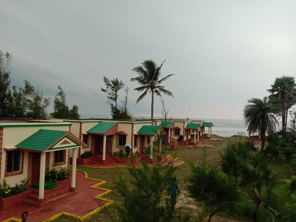 a row of houses with the ocean in the background at Green Valley Hotel and Resort- Resort in Mandarmoni