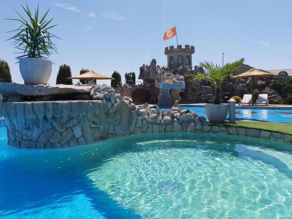 uma piscina num resort com uma parede de pedra em Motel pizzeria Actros em Nova Topola