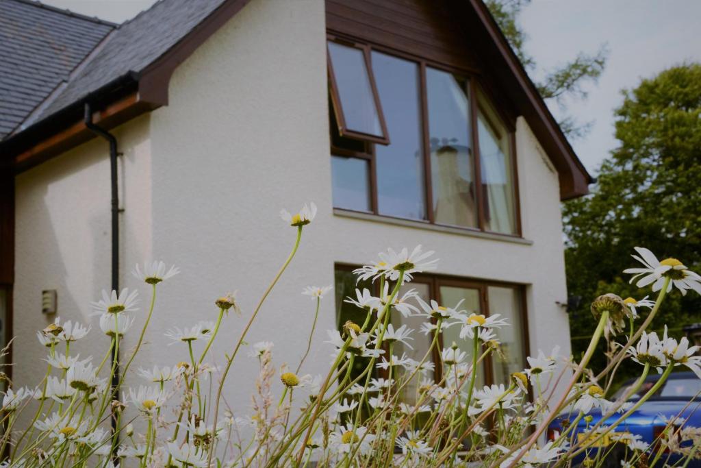 una casa con flores blancas delante de ella en Torcastle House, en Fort William