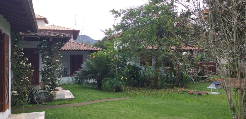 a backyard of a house with a yard with trees at Bangalôs Parque Verde in Paraty