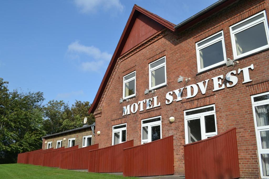 a red brick building with the words world stylewest at Motel Sydvest in Skærbæk