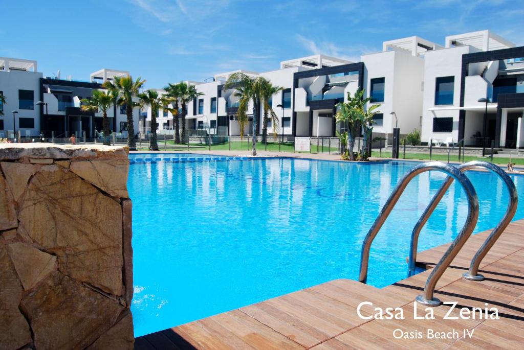 a swimming pool in front of some apartment buildings at Casa La Zenia in Playas de Orihuela