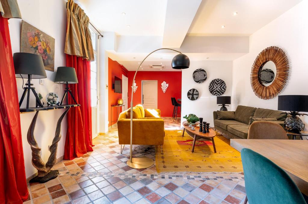 ein Wohnzimmer mit einem Sofa und einem Tisch in der Unterkunft PLACE DU PALAIS DES PAPES 3 chambres Parking Climatisation 3 Salles de bain in Avignon