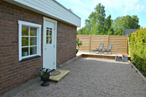 een bakstenen gebouw met een patio met 2 stoelen bij Båstad in Båstad