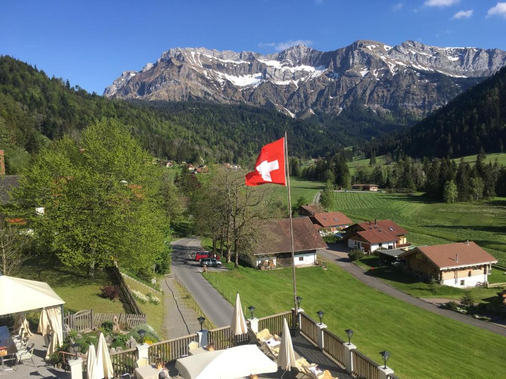 una bandera canadiense ondeando frente a una montaña en Hotel Restaurant Hammer, en Eigenthal