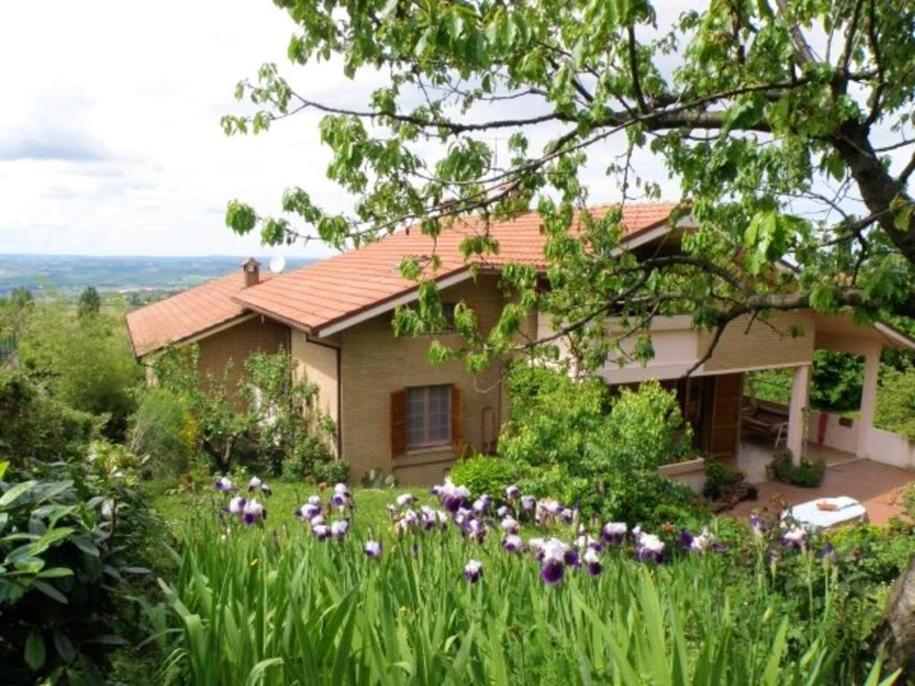 dom z polem kwiatów przed nim w obiekcie Charming House near Monteciccardo with Private Pool w mieście Monteciccardo