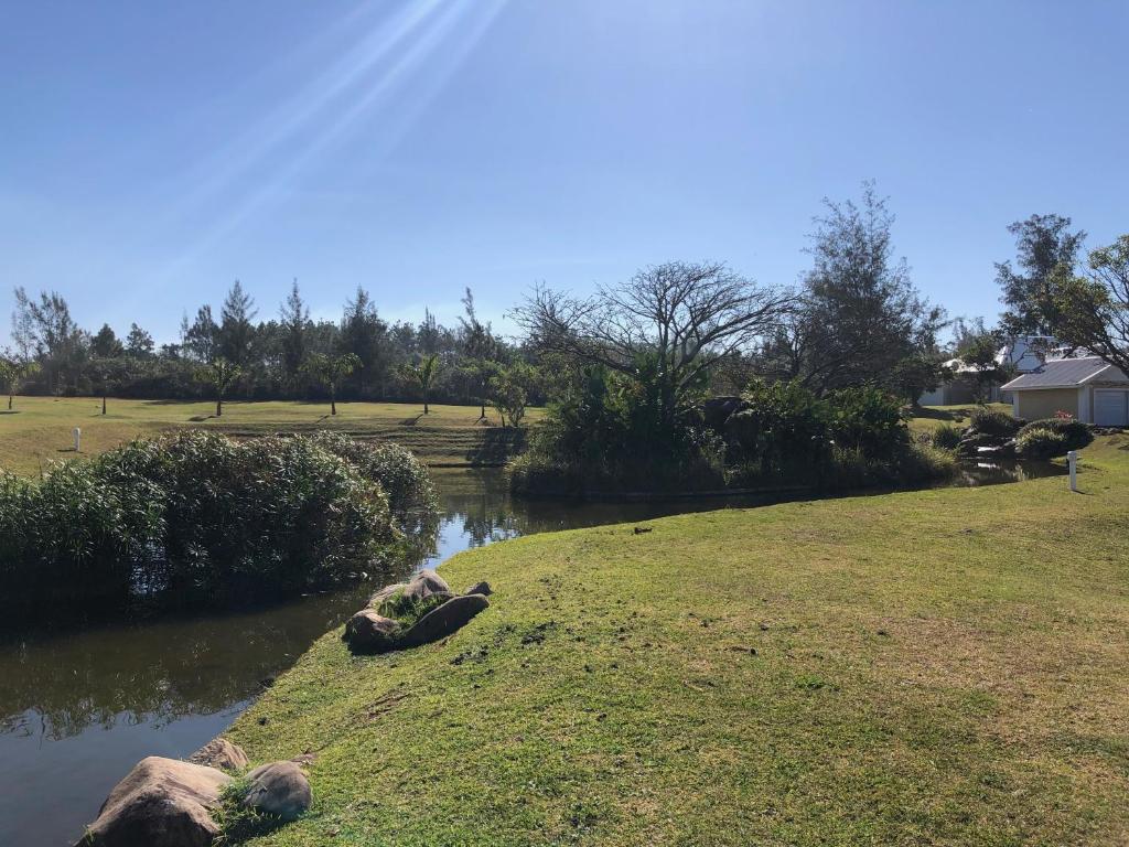 a river with rocks on the side of a field at Caribbean Estates Villa 1131 in Port Edward