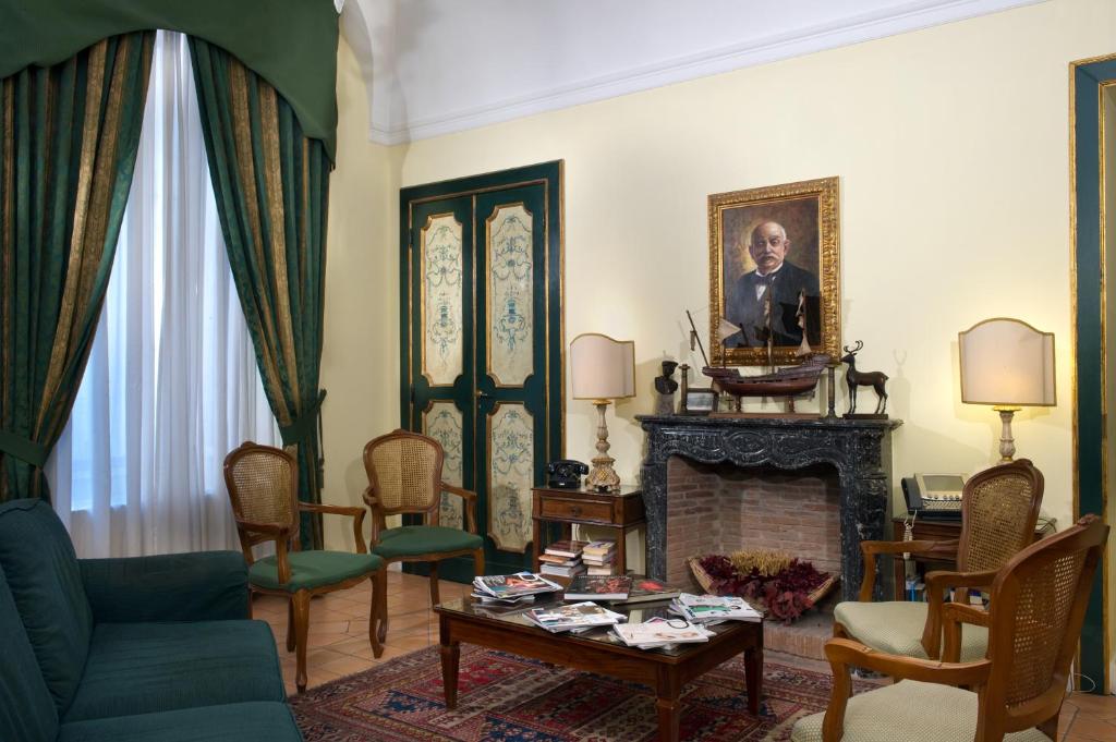 una sala de estar con chimenea y un retrato de un hombre en Chiaja Hotel de Charme, en Nápoles