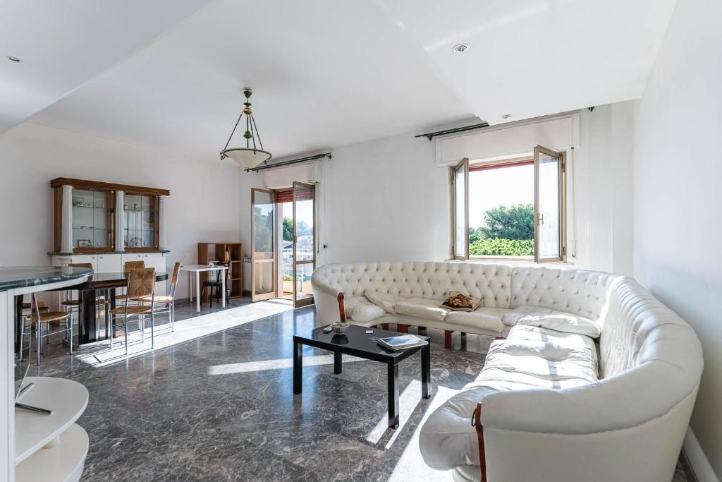 ein Wohnzimmer mit einem weißen Sofa und einem Tisch in der Unterkunft Anita Domus - Appartamento con vista a Pescara in Pescara
