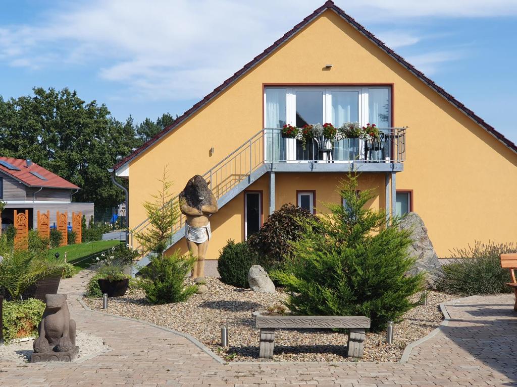 ein gelbes Haus mit einem Balkon und einer Bank in der Unterkunft Apartmenthaus in Walle in Walle