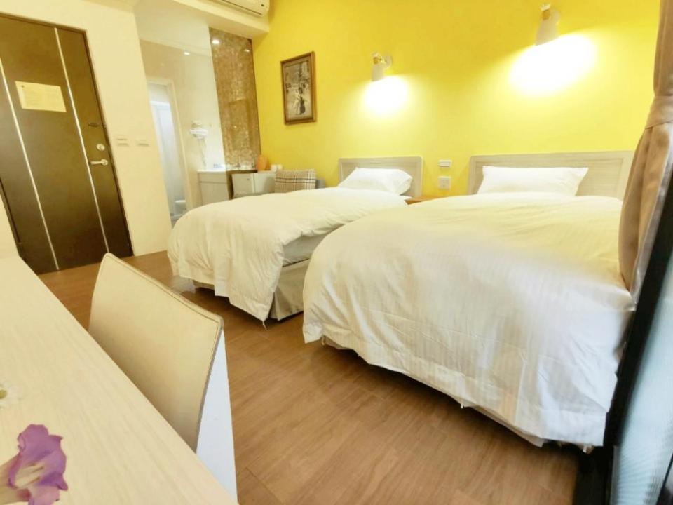 LongjingにあるDonghae13.8のベッド2台とテーブルが備わるホテルルームです。