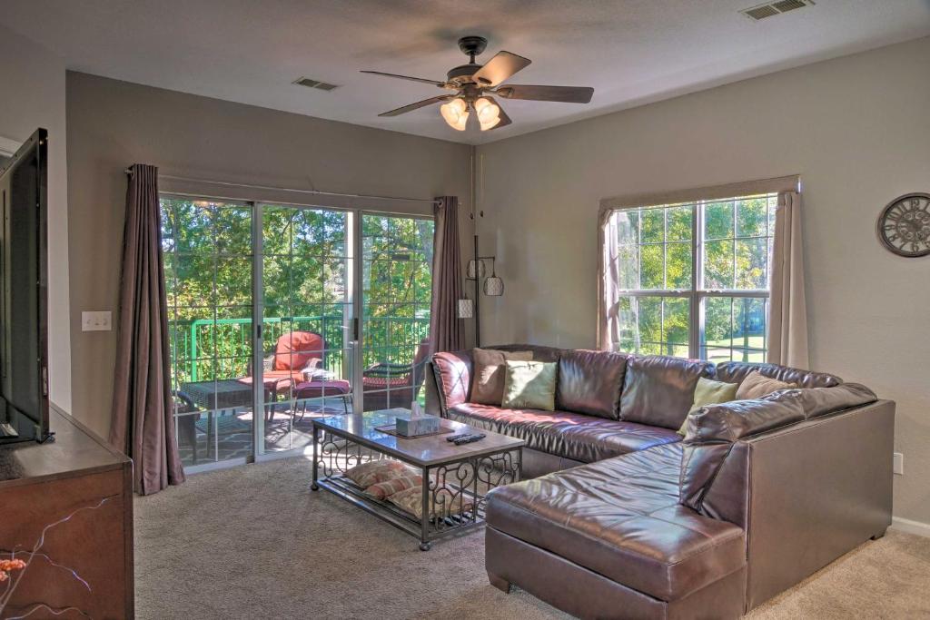 a living room with a couch and a table at Resort Condo with Patio, 5 Mi to Branson Landing! in Branson