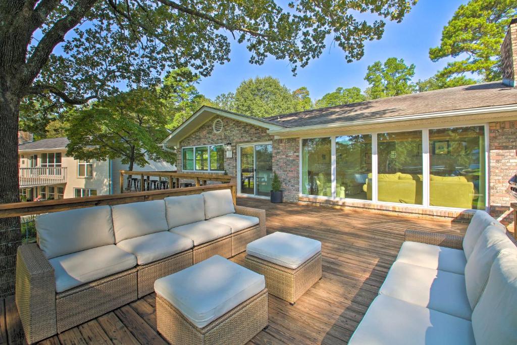 un patio con sofás y mesas en una terraza de madera en Stunning Hot Springs Getaway on Lake Hamilton, en Hot Springs