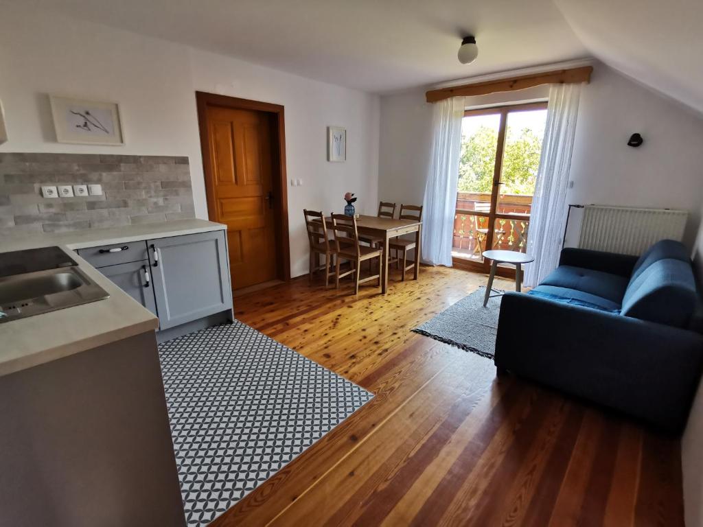 ein Wohnzimmer mit einem blauen Sofa und einem Tisch in der Unterkunft Apartma Lesjak - pobeg v naravo in Mozirje