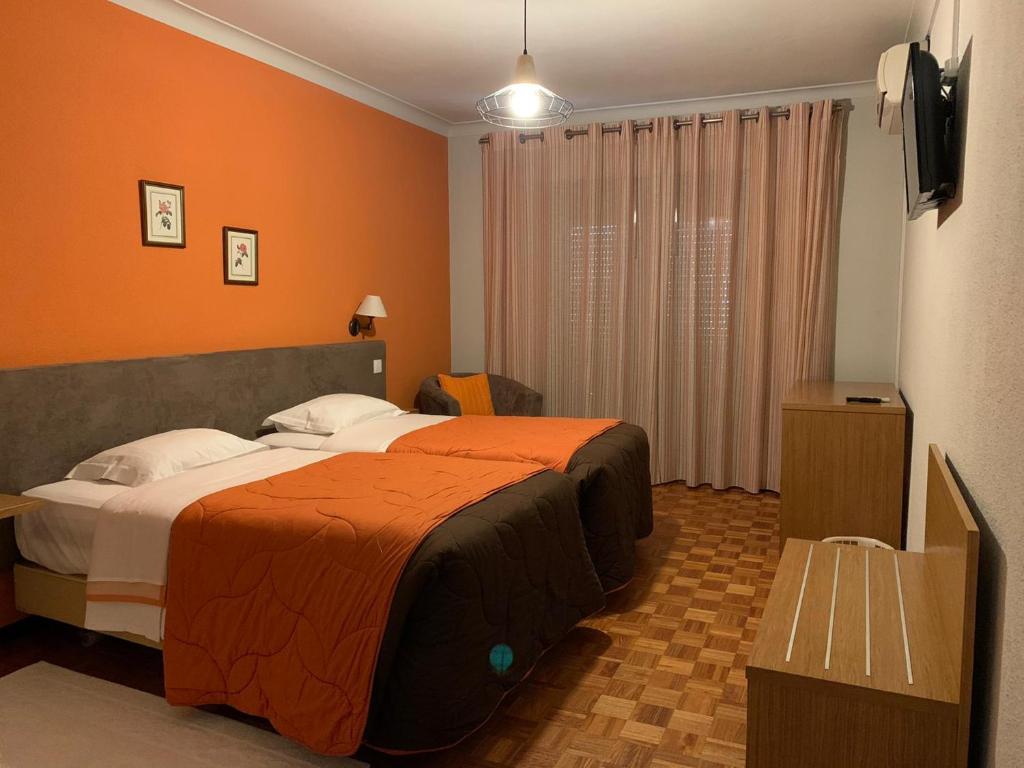 um quarto de hotel com duas camas e uma televisão em Hotel Ribadouro em Alijó