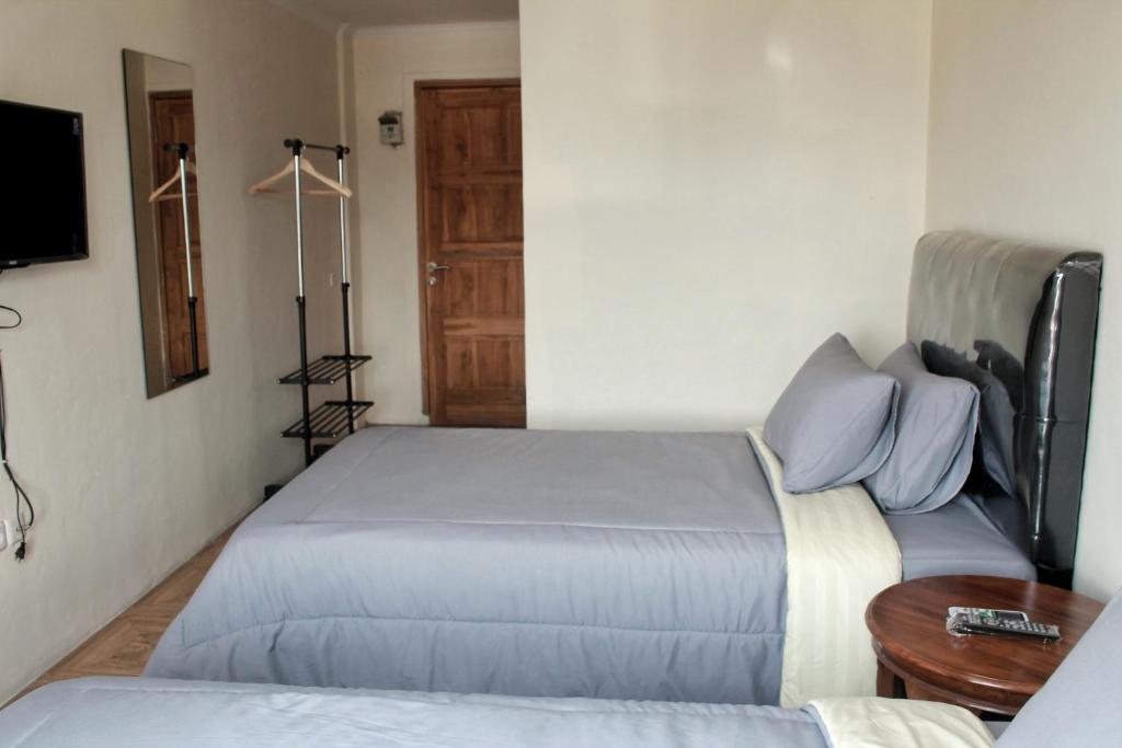 - une chambre avec 2 lits, une table et une porte dans l'établissement bumimakhraja syariah 4, à Bandung