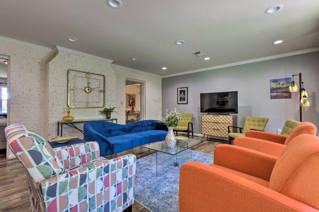 a living room with orange chairs and a blue couch at Ocean Springs Home - Walk to Beach and Downtown! in Ocean Springs