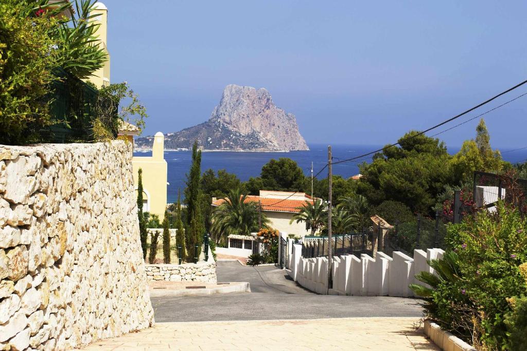 a view of a mountain in the ocean from a street at Casa Montesol in Calpe