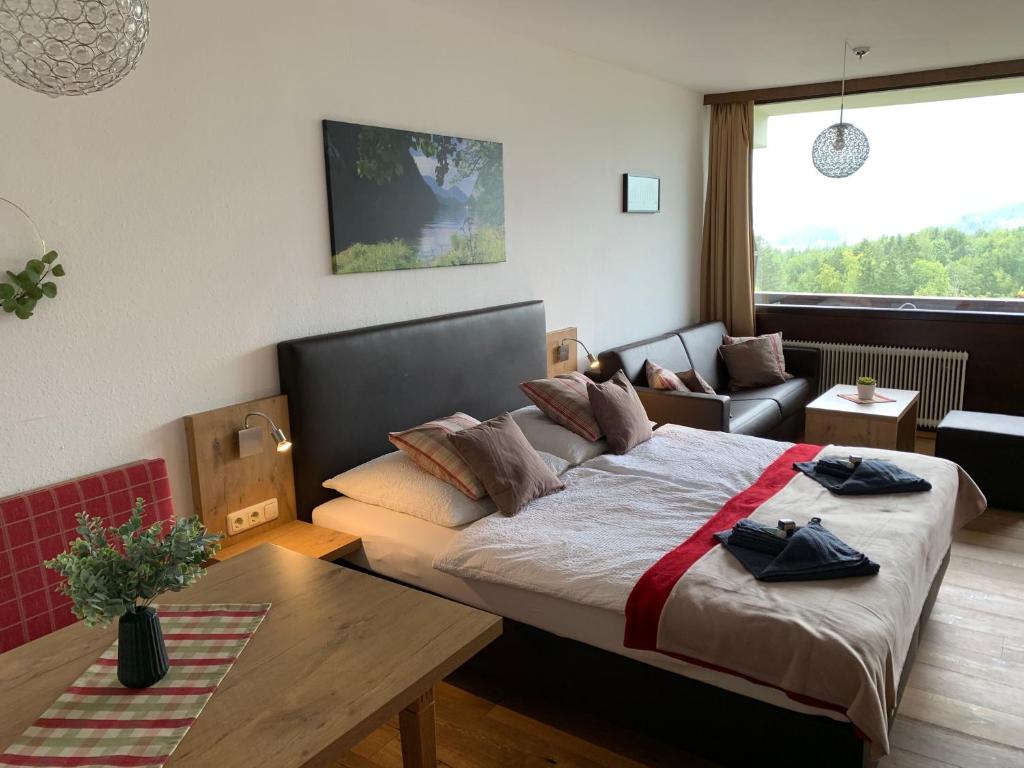 a bedroom with a bed and a couch and a table at Goisererglück in Bad Goisern