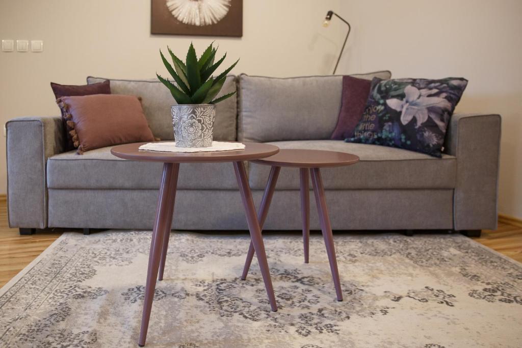 a living room with a couch and two tables at Apartment Nobl plac in Celje