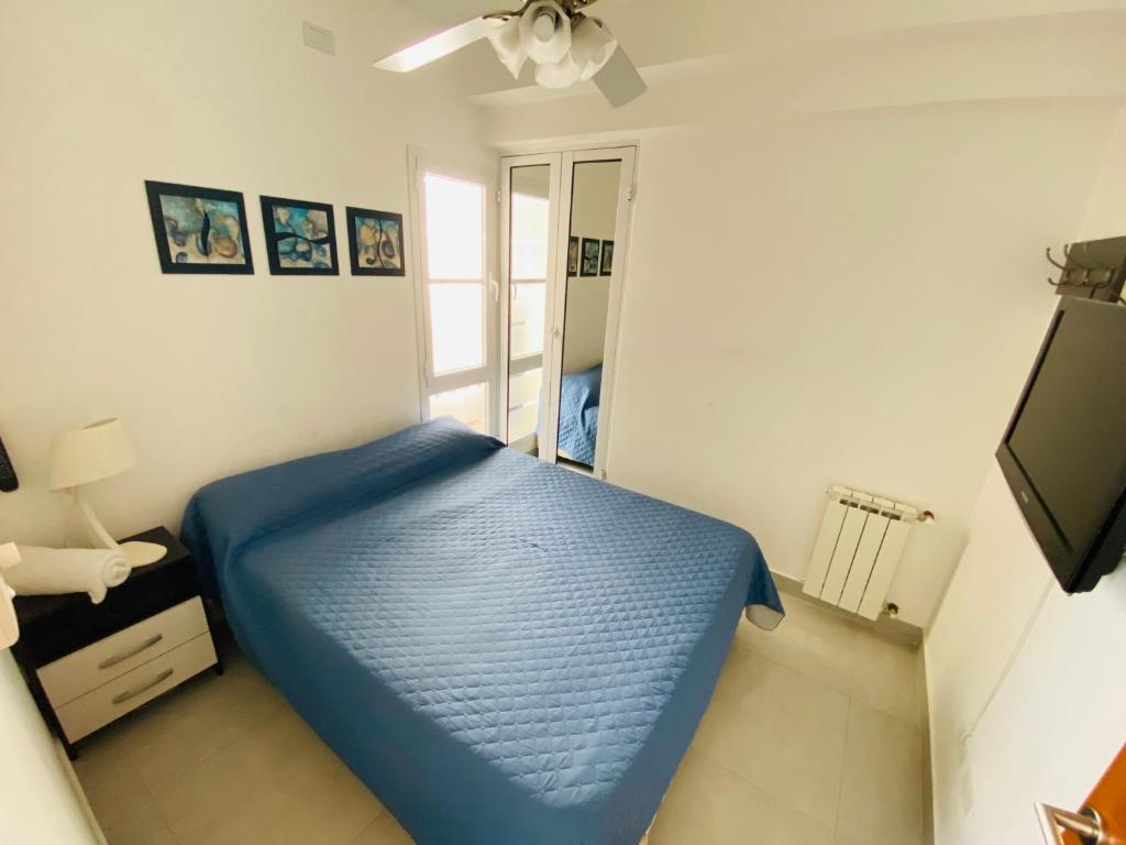 um quarto com uma cama azul e uma ventoinha de tecto em Departamento moderno pleno centro salta capital em Salta