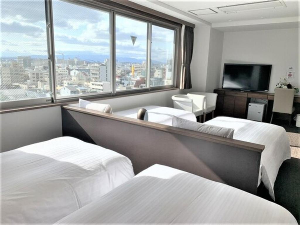 大阪市にあるバンデホテル大阪 - Vacation STAY 98159のベッド2台と大きな窓が備わるホテルルームです。
