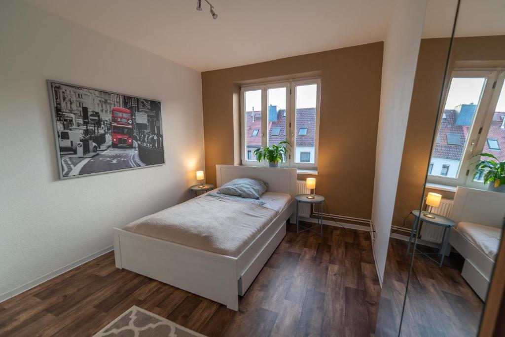 una piccola camera con un letto e due finestre di 2 Bedroom 65qm - Kitchen - Central - Netflix a Magdeburgo